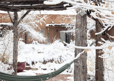 hammock in front of snow covered adobe