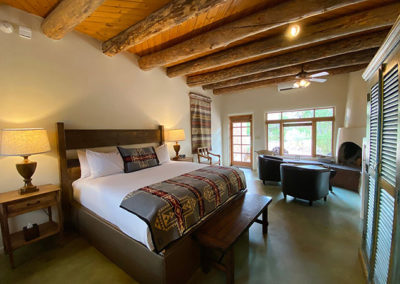queen size bed in hotel with southwestern throw blanket and kiva fireplace