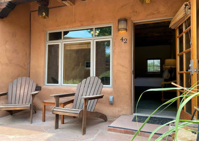 adobe hotel room porch with adriondack chairs