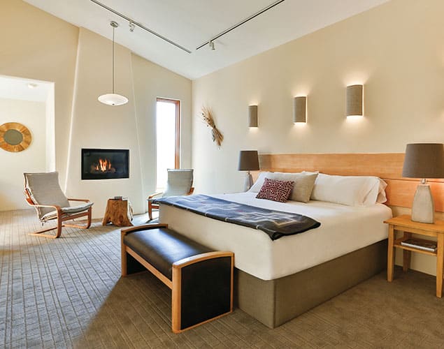 Hotel Suite Casita Interior of room with queen bed, gas fireplace, chairs and lights Hotel Suite Casita Interior of room with queen bed, gas fireplace, chairs and lights